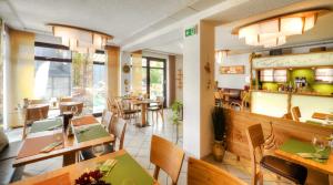 伦斯泰格地区施米德费尔德仁斯特格鲁鲍酒店的一间在房间内配有桌椅的餐厅