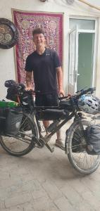 布哈拉Guest house IBROHIM حلال的一个人站在自行车旁边