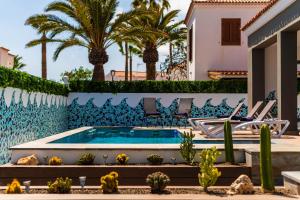 阿罗纳Villa De Marcos的一座别墅,设有游泳池和棕榈树