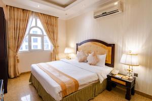 马斯喀特Garden Hotel Muscat By Royal Titan Group的一间卧室设有一张大床和一个窗户。