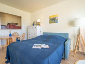 基伯龙Studio Les Albatros-1 by Interhome的一间卧室配有一张蓝色的床和一张桌子
