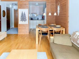 于莱Holiday Home Ylläs chalets a307 by Interhome的厨房以及带桌子和沙发的客厅。