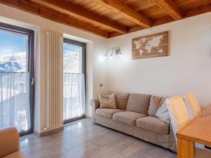 SueglioHoliday Home Marcello by Interhome的带沙发和2扇大窗户的客厅