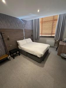 洛斯托夫特Hatfield Lodge的一间卧室配有一张床和一张书桌
