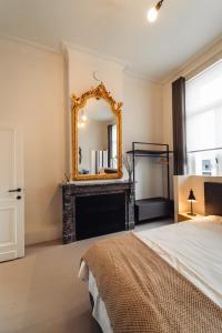 赫伦塔尔斯Luxeverblijf B&B het Wevershuis的一间卧室设有壁炉和镜子