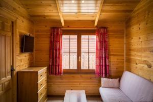 阿兰约兹Aranjuez Camping & Bungalows的木制客房设有沙发和窗户。