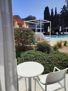 克里斯托港Sol i Vida Hotel - Adults Only的游泳池旁的白色桌椅