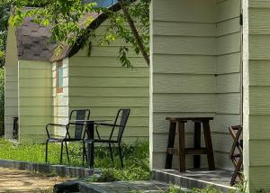 大叻Cottage Retreat DALAT的房子前面的两把椅子和一张桌子