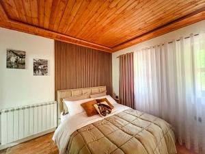 泰斯Logu i Harushave的一间卧室设有一张带木制天花板的大床