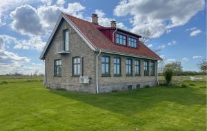 Sankt IbbCozy Home In Sankt Ibb With Kitchen的绿色田野上一座红色屋顶的房子