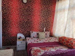 索兰Solan Regncy的一间卧室设有一张床和红色的墙壁