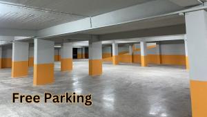 都拉斯Blumont Aparthotel Durres的一个空的停车场,有橙色和白色的柱子