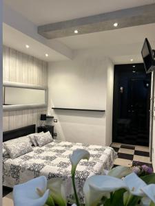 蒙特罗索阿尔马雷Affittacamere 4 bassotti的一间卧室配有一张床、一台电视和鲜花