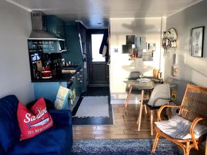 布莱顿霍夫Brighton Water Cabin - a unique floating holiday home的一间带蓝色沙发的客厅和一间厨房