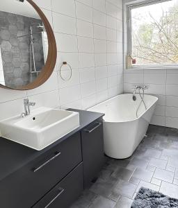斯德哥尔摩The Luxurious Lakeview Villa near Stockholm的一间带水槽、浴缸和镜子的浴室