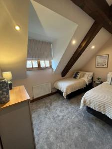 赫恩Rare & exclusive country cottage的阁楼间 - 带两张床和窗户