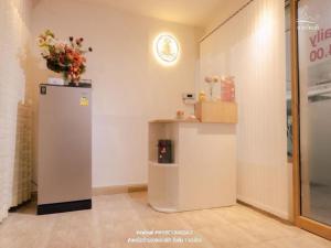 曼谷Super OYO Capital O 564 Nature Boutique Hotel的一间设有冰箱和鲜花架的房间