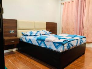 甘托克RIGS Homestay的一间卧室配有一张带蓝色床单和蓝色枕头的床。