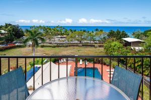 科纳Kahaluu Bay Villas 304的阳台享有游泳池和海洋的景致。