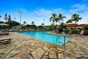 科纳Keauhou Kona Surf & Racquet Club #5-303的度假村内带椅子和棕榈树的游泳池