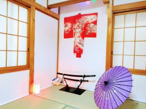 名古屋Masaki 1chome house的一间设有紫色伞和墙壁的房间