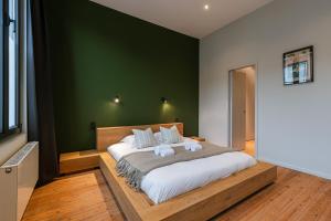 安特卫普Charming urban retreat 15 Minutes from Central Station的一间卧室设有一张大床和绿色的墙壁