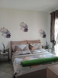 奥罗塞伊Vivere in famiglia的卧室内的一张床铺,墙上挂着鲜花