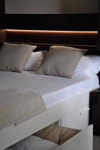 卡略萨登萨里亚Camping Fonts del Algar的白色的床、白色床单和枕头