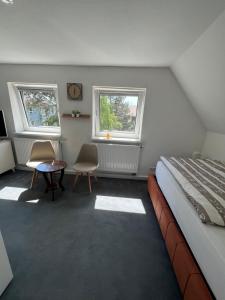 卡塞尔Ferienhaus Cassel的一间卧室配有一张床、一张桌子和两个窗户