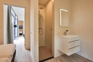 泽赫瑟Zeegser Duinen Suitelodges的浴室配有白色水槽和淋浴。