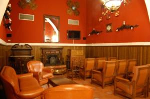 瓜达卢佩库拉索德锐欧教堂酒店的客厅配有橙色椅子和壁炉