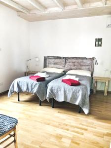 PilzoneCasa del Nespolo的一间卧室设有两张床,铺有木地板