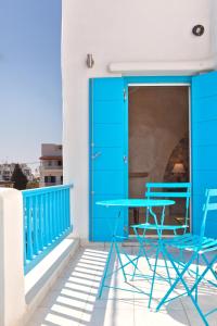 提诺斯TINOS AQUA PALAZZO的阳台配有一张蓝色的桌子和两把椅子