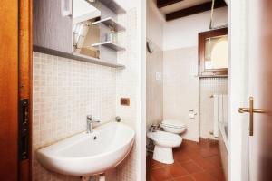 皮亚琴察Il Lusso Della Semplicità的白色的浴室设有水槽和卫生间。