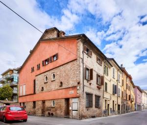 皮亚琴察Il Lusso Della Semplicità的停在砖楼前的红色汽车
