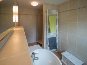 斯匹科罗格Spiekerhorst的浴室配有白色浴缸和绿色窗户。