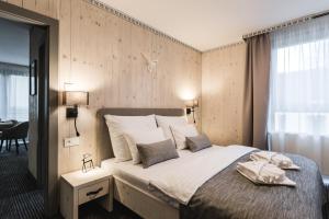 塔特兰斯卡斯特拉ARIETES MARMONT Resort的一间卧室配有一张大床和两条毛巾
