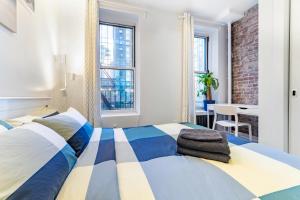 纽约2 Bedroom Luxury Unit in the Heart of Manhattan的卧室配有蓝色和白色的床和书桌。