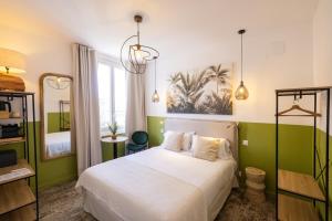 比亚里茨Hôtel Barnea的一间卧室配有白色的床和绿色的墙壁