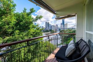 布里斯班Riverside studio apartment with parking and view的阳台设有长凳,享有城市美景。