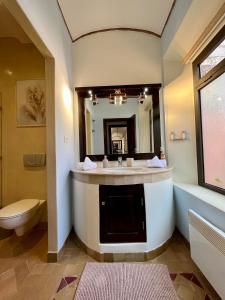 马拉喀什Villa Sofia - Golf Amelkis Marrakech的一间带水槽、卫生间和镜子的浴室