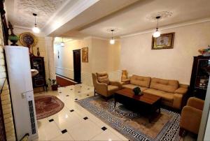 撒马尔罕KAMILA Hotel Boutique的客厅配有沙发和桌子