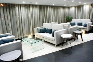 普拉亚Beramar Hotel的带沙发、桌子和窗帘的客厅