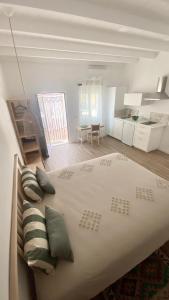 塔维拉Quinta Almargem Lusitano - Farm House的白色卧室配有带枕头的大床