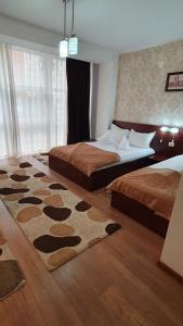 阿拉德Pensiunea Select的卧室配有两张床,地板上铺有地毯。