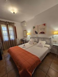 帕萨若帕萨龙乡村酒店的一间卧室配有一张带橙色毯子的大床