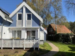 布雷格Sehr schönes Haus in Breege zwischen Hafen und Strand mit neuer Sauna und Kamin的白色的蓝色房屋,设有白色的围栏