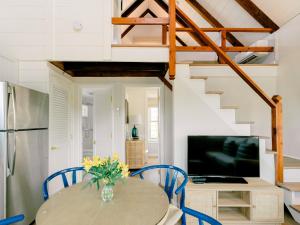 楠塔基特The Cottages & Lofts的厨房以及带桌子和蓝色椅子的用餐室。