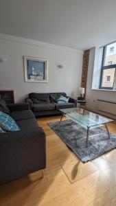 伦敦Impeccable 2-Bed Apartment in London的带沙发和玻璃桌的客厅