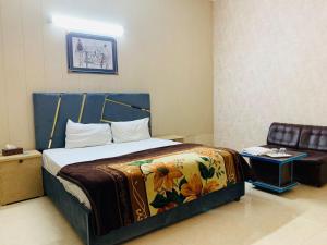 拉合尔Hotel Royal Fort的一间卧室配有一张带毯子和椅子的床